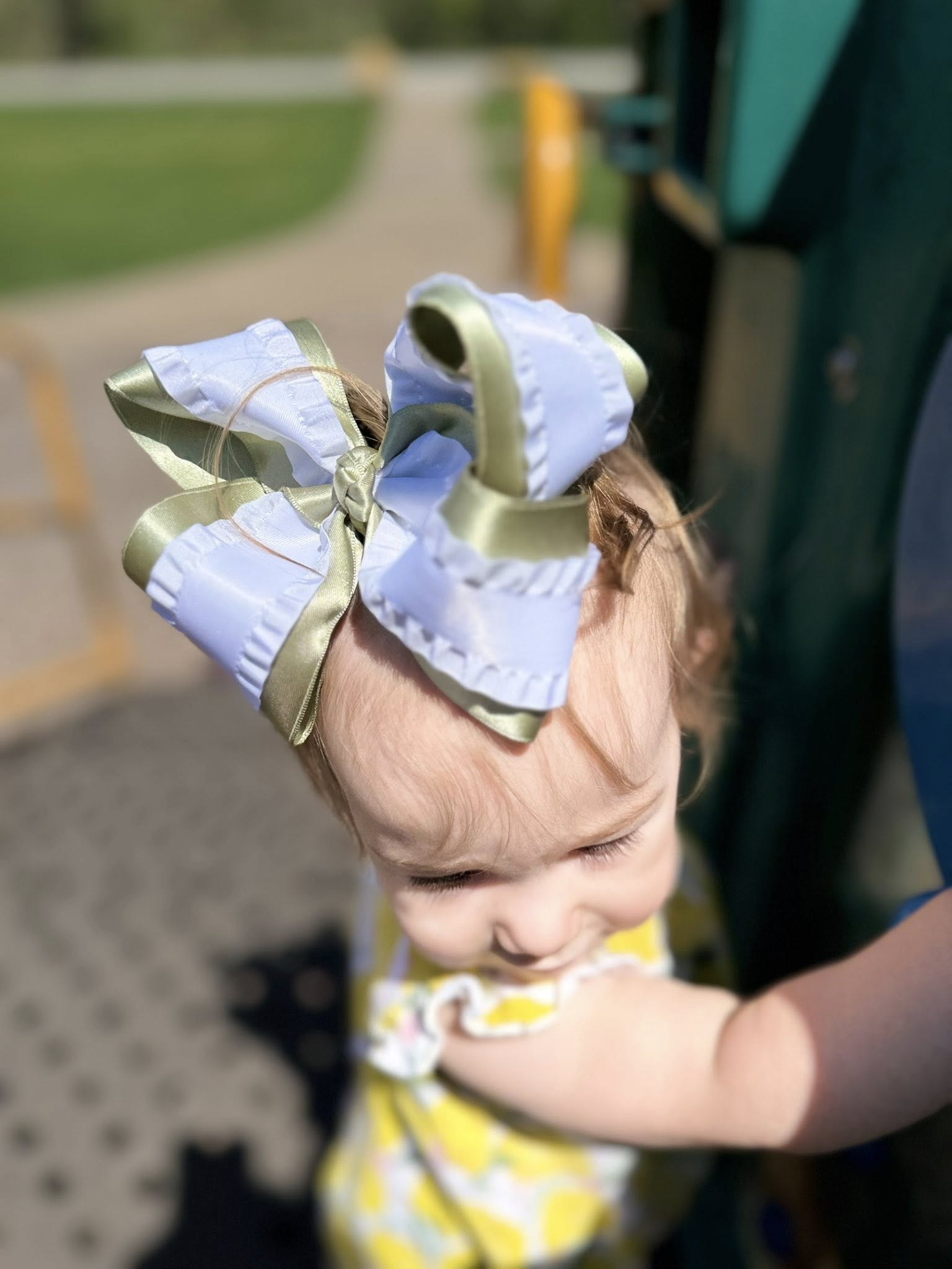 A child wearing a luxury white and sage Willow and Bow hair bow