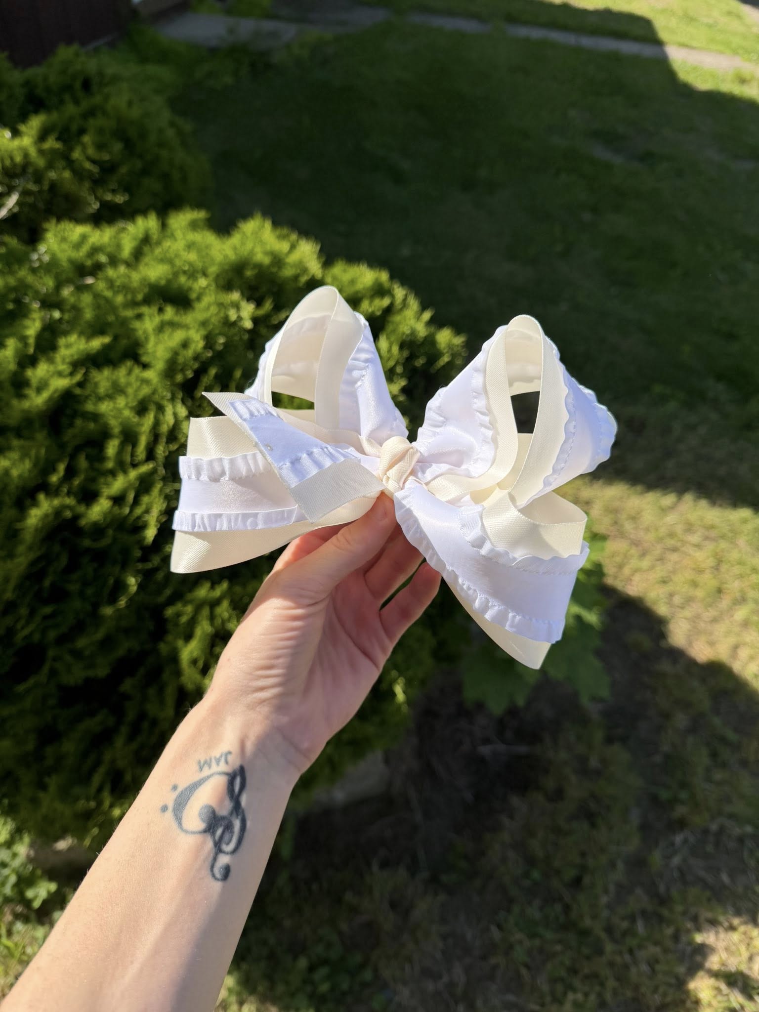 A white boutique bow with ruffle trim